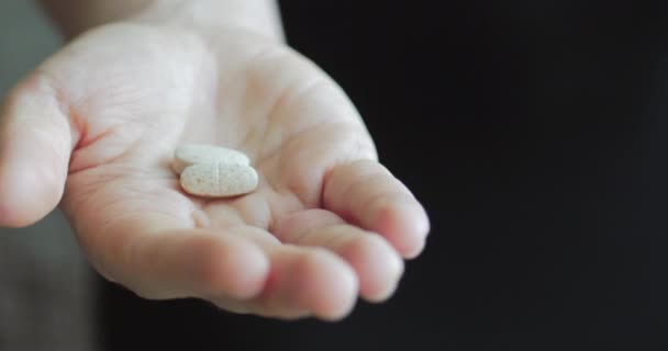 Gros plan sur les mains des femmes, quelqu'un verse un paquet de comprimés d'opiacés sur ordonnance dans la main. Concept de santé, médicaments, contraception . — Video