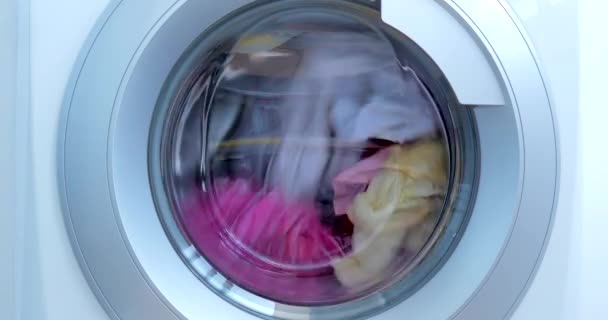 Close Up Průmyslová pračka myje barevné oblečení a bílé povlečení, bílé pruhované oblečení. Cylindrický točící stroj. Koncept Praní prádla pračka, průmysl Praní prádla. — Stock video