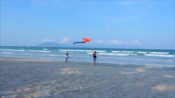 Lycklig mormor med barn att spela flygande kite, familjen körs på sanden i en tropisk Ocean leker med den äldre draken. Concept Happy och bekymmerslös barndom. — Stockvideo