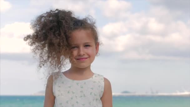 Gros plan Portrait d'une belle petite fille, sourire mignon, regarder la caméra. Concept : Enfants, Enfance, Eté, Bébé fille . — Video