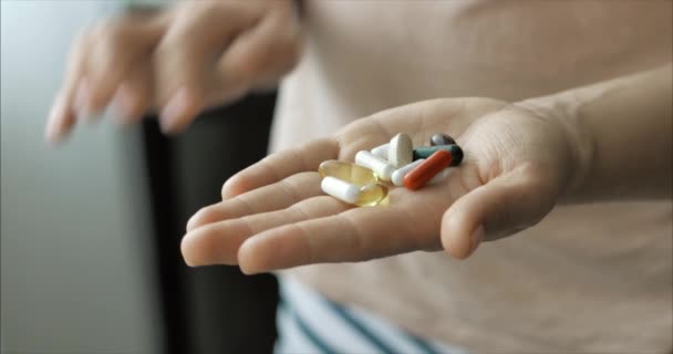 Närbild av kvinnliga händer, häller någon en massa receptbelagda opiat piller i handen. Begreppet hälsa, droger, preventivmedel. — Stockvideo