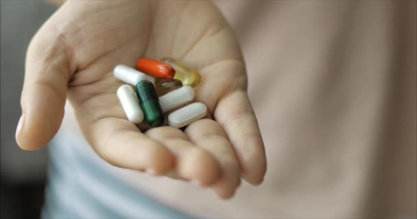 Close-up de mãos femininas, alguém derrama um monte de comprimidos de opiáceos de prescrição na mão. Conceito de Saúde, Drogas, Contracepção . — Vídeo de Stock