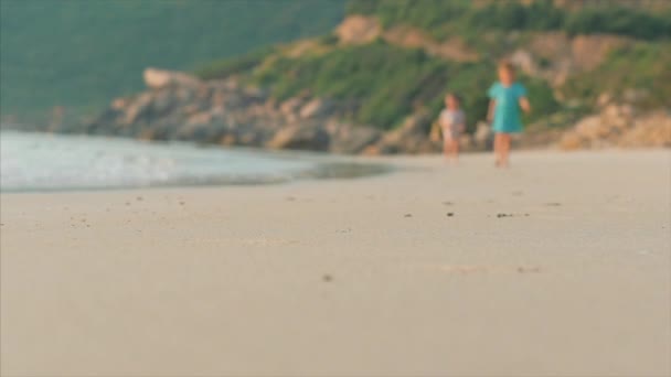 Sziluettje gyermek láb Walking on nedves homok mentén egy trópusi tengerparton egy trópusi óceáni háttérben. Koncepció: gyerekek, boldog gyermekkor, nyár, gyermek, Vacation. Lágy fókusz. — Stock videók