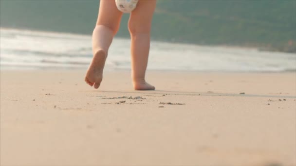 Silueta kojenů chůze po mokrém písku podél tropické pláže na pozadí tropického oceánu. Koncept: děti, šťastné dětství, léto, dítě, dovolená. Měkké zaměření.