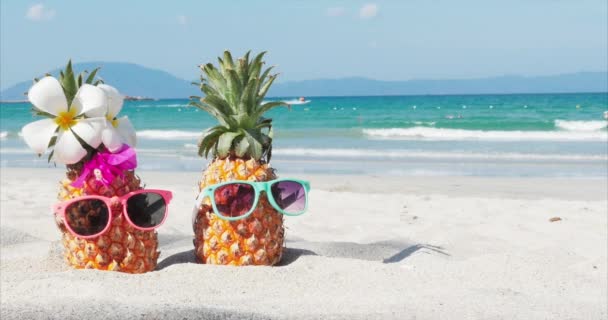 Σε μια τροπική παραλία κοντά στο κάτω από το ζεστό καλοκαίρι του ήλιου κατά μήκος της τροπική εξωτική ακτή στέκεται πάνω στην άμμο τροπικά φρούτα. Concept καλοκαιρινό φόντο. — Αρχείο Βίντεο