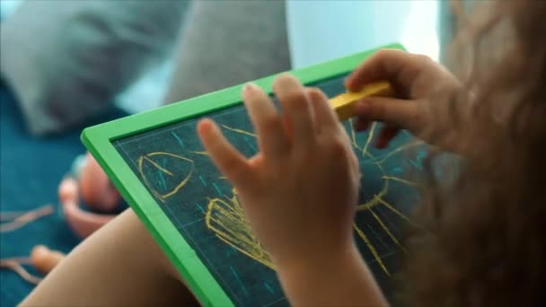 Junge Hände des Künstlers, kleine Kinderkünstler bemalt eine Leinwand mit Graphitstiften, sitzt an einem Tisch und zeichnet auf Leinwand. Prozess des Zeichnens: im Künstleratelier Hand Baby Girl Skizzen auf Leinwand. — Stockvideo