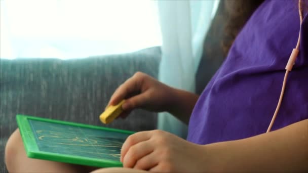 Junge Hände des Künstlers, kleine Kinderkünstler bemalt eine Leinwand mit Graphitstiften, sitzt an einem Tisch und zeichnet auf Leinwand. Prozess des Zeichnens: im Künstleratelier Hand Baby Girl Skizzen auf Leinwand. — Stockvideo