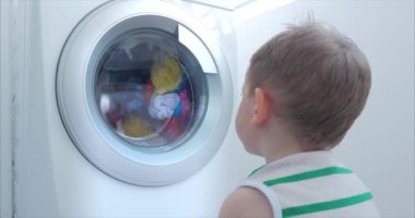 Sevimli Çocuk Çamaşır Makinesi nin İçine Bakıyor. Silindir İplik Makinesi. Konsept Çamaşır Yıkama Makinesi, Sanayi Çamaşırhane Servisi.
