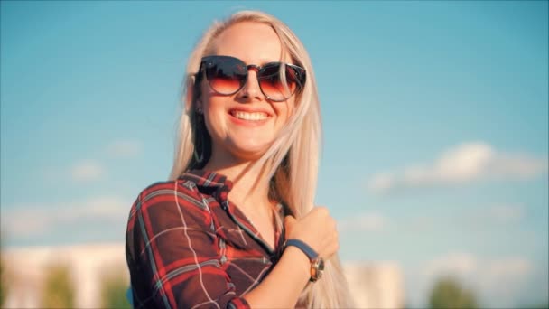 Close-up portret van Europese mooie schattige blonde in met Sunglass jonge vrouw of vrolijk meisje op zoek in de camera, waait wind haar de wind, Slow Motion. — Stockvideo