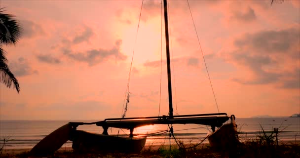 Vacker solnedgång i tropikerna på bakgrunden av Ailboat på sanden och havet. Koncept natur, semester, Relaxe. Mjukt fokus. — Stockvideo