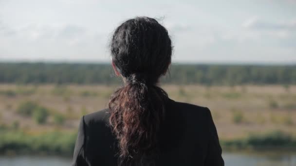 Unga affärskvinna tittar på utsikten från berget vid solnedgången, framgångsrik flicka som funderar på livet i naturen, njuter av landskapet natur bakgrund njuter av frihet, fritid resor. — Stockvideo