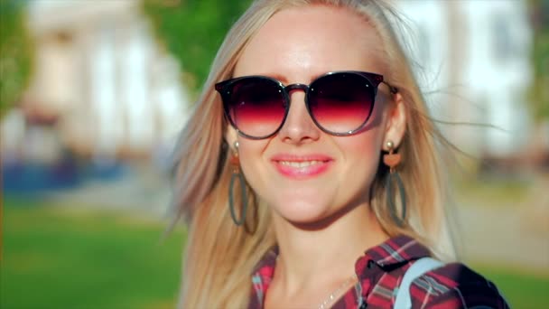 Portré az Európai aranyos szőke a sunglass fiatal boldog asszony vagy vidám lány keres a kamera, fújás szél haja a szél, lassított. — Stock videók