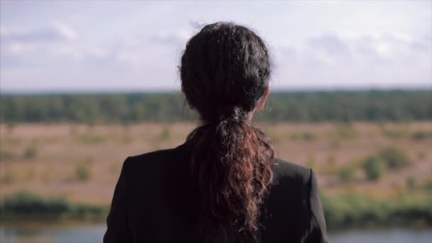 Joven mujer de negocios mirando al cielo al atardecer, chica exitosa pensando en la vida en la naturaleza, disfrutando del paisaje fondo de la naturaleza disfrutando de la libertad, viajes de ocio . — Vídeo de stock