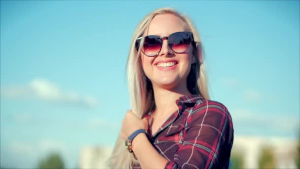 Gros plan Portrait d'une belle blonde mignonne européenne avec des lunettes de soleil Jeune femme ou fille joyeuse regardant dans la caméra, Vent soufflant Cheveux le vent, Mouvement lent . — Video