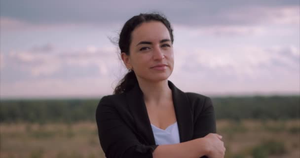 Retrato Mujer joven mirando a la cámara al atardecer, Chica exitosa pensando en la vida en la naturaleza, disfrutando del paisaje Fondo de la naturaleza Disfrutando de la libertad, viajes de ocio . — Vídeo de stock