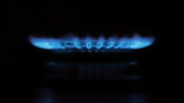 Siyah arka planda gaz sobası. Gaz yanıyor, mavi alev yanıyor..