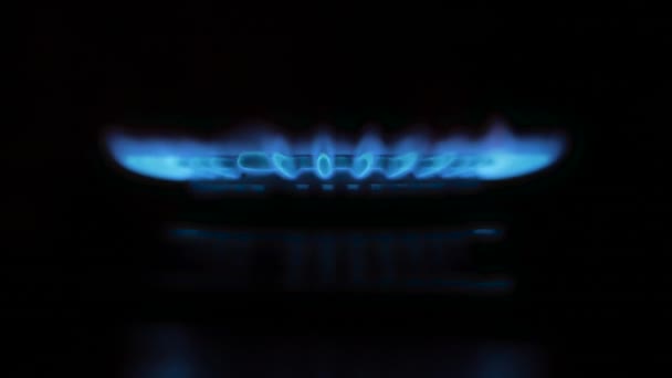 Gasherd auf schwarzem Hintergrund. Gas schaltet sich ein und entzündet blaue Flamme. — Stockvideo