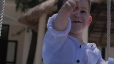 Bir Salıncak ta Happy Child Ride. Mutlu çocukluk, yaz tatili. Mutlu Küçük Çocuk salıncakta sürme gülümseyen.