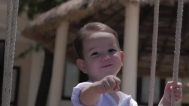 Bir Salıncak ta Happy Child Ride. Mutlu çocukluk, yaz tatili. Mutlu Küçük Çocuk salıncakta sürme gülümseyen.