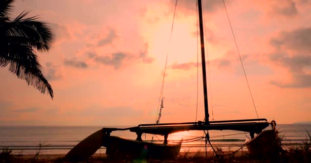 Vacker solnedgång i tropikerna på bakgrunden av Ailboat på sanden och havet. Koncept natur, semester, Relaxe. Mjukt fokus. — Stockvideo