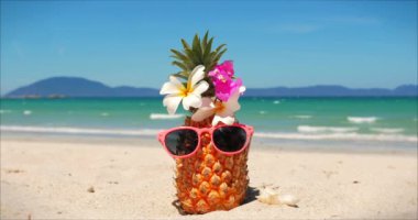 Tropikal egzotik sahil boyunca sıcak yaz güneşi altında güneş gözlüğü meyve tropik plaj yakın çekim üzerinde, okyanus arka plan üzerinde güneş gözlüğü ananas. Konsept topikal, yaz, parti, tatil.