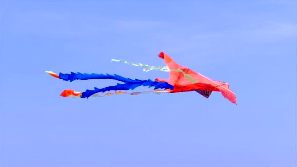 Foto van een vlieger vliegen in de lucht op een zonnige dag tegen een blauwe hemel en witte wolken en blauw. — Stockvideo