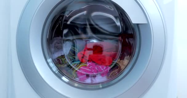 Закрыть Промышленная стиральная машина стирает цветную одежду и белое белье, белую полосатую одежду. Крутящаяся цилиндрическая машина. Концепция стиральная машина, прачечная. — стоковое видео