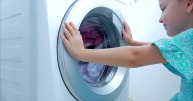 Sevimli Çocuk Çamaşır Makinesi nin İçine Bakıyor. Silindir İplik Makinesi. Konsept Çamaşır Yıkama Makinesi, Sanayi Çamaşırhane Servisi.