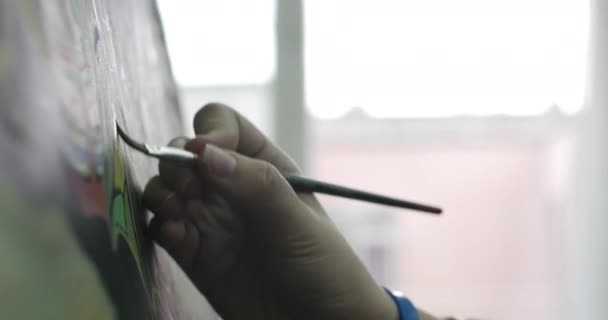 Tekening proces: in de kunst studio van de kunsten kunstenaars hand Art Girl met een penseel schilderij op canvas. — Stockvideo