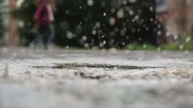 Düşük açı, yakın çekim, tanınmaz çocuklar yağmurdan sonra yaz günü su birikintileri arasında koşuyorlar. Tasasız çocuklar su birikintilerinde koşarlar. Mutlu bir çocukluk kavramı.