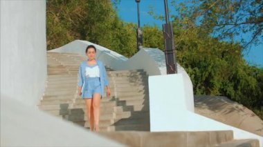 Merdivenlerden Aşağı İş Lady, Mavi Takım Elbiseli Çekici Esmer Elinde Bir Laptop Ile Merdivenlerde Gidiyor. Merdivenlerden Aşağı Yüksek Bej Topuklu Kadın Bacaklar. Kısa Elbiseli Çekici Kız.