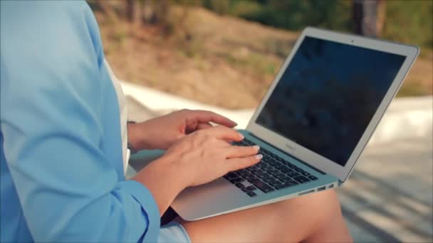 Biznes Lady praca na laptopie, atrakcyjna brunetka w niebieskim garniturze z laptopem, atrakcyjna kobieta pracuje na swoim komputerze na zewnątrz. — Wideo stockowe