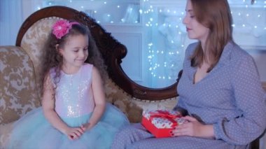 Onun Little Sweet Daughter ile Genç Mutlu Anne Bir Hediye Açın, Noel Ağacı Arka Planda İçe Bak ve Sevin.