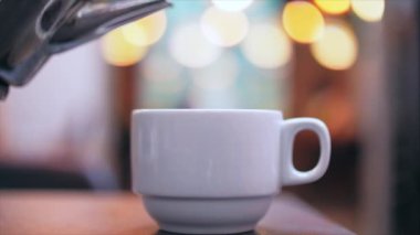 Kettle 'Dan çay yavaşça porselen kupaya dökülür.