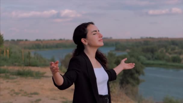 Joven mujer de negocios mirando al cielo al atardecer, chica exitosa pensando en la vida en la naturaleza, disfrutando del paisaje fondo de la naturaleza disfrutando de la libertad, viajes de ocio . — Vídeos de Stock