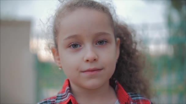 Close-up portret van een schattig gelukkig Kaukasische meisje het maken van een verrast gezicht en dan glimlachend kijken naar de camera genieten van een warme zomerdag bij zonsondergang. — Stockvideo