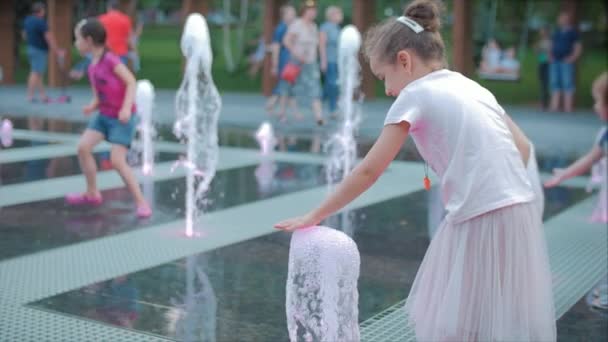 Gelukkig klein meisje in de stad spelen met water in fonteinen, gelukkige en zorgeloze kindertijd, het concept van vrijheid en geluk in de kindertijd, zomer vakantie. — Stockvideo