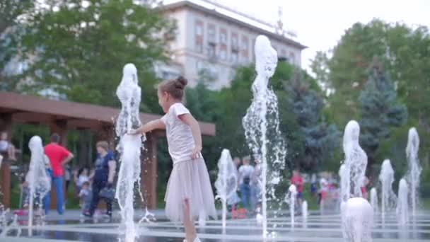 Petite fille heureuse en ville jouant avec l'eau dans les fontaines, enfance heureuse et insouciante, le concept de liberté et de bonheur dans l'enfance, vacances d'été . — Video