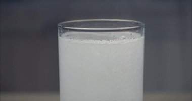 İki aspirin tableti bir bardak kristal berraklığında suya düşer, bir bardak suda gazlı kabarcıklar. Sağlık Kavramı.