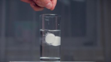 İki aspirin tableti bir bardak kristal berraklığında suya düşer, bir bardak suda gazlı kabarcıklar. Sağlık Kavramı.