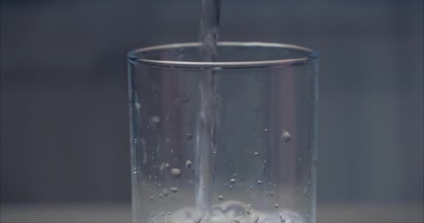 Κοντινό ρίχνει φρέσκο καθαρό νερό από το μπουκάλι σε ένα γυαλί στο τραπέζι. Έννοια υγεία. — Αρχείο Βίντεο