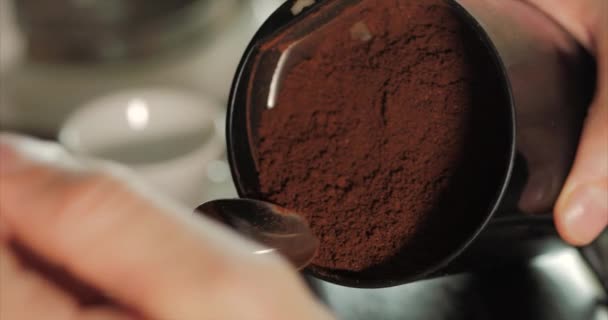 Mão marca uma colher de café natural moído na hora do moedor. Brew café da manhã cheiroso. Preparação de uma bebida revigorante quente Descafeinado . — Vídeo de Stock