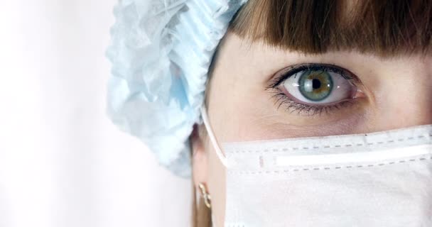 Portret z bliska kobieta chirurg, lekarz z maska gotowa do pracy w szpitalu lub przychodni. Lekarze oczy — Wideo stockowe