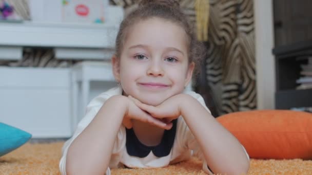 Retrato de um rosto bonito meninas close-up. Menina bonita olha para a câmera e sorri docemente . — Vídeo de Stock