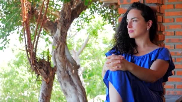 Mujer atractiva disfruta de la naturaleza, una mujer mira hacia otro lado, cuidadosamente mira a la naturaleza . — Vídeos de Stock