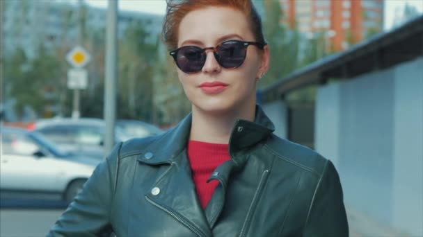 Retrato de una atractiva joven sonriente con gafas cara de cerca de una mujer feliz con el pelo largo y rojo de buen humor, emociones positivas . — Vídeos de Stock