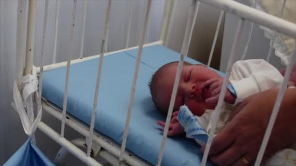 Mother Picks Up Her Newborn Baby From the Crib After Giving Birth. Newborn Baby Lying in Bed After Childbirth. Concept of the Hospital. — Stockvideo