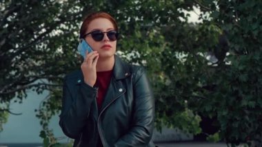 Bir Kentsel Ayarı Yürürken, Sokakta Bir Cep Telefonu konuşurken güneş gözlüğü genç kadın.