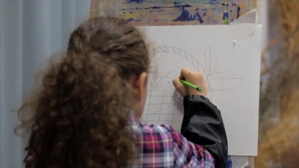 アーティストのリトルガール若い手、リトルウーマンアーティストは、ブラシでキャンバスをペイントし、テーブルに座ってキャンバスに描きます。描画のプロセス:アーティストアートスタジオで — ストック動画