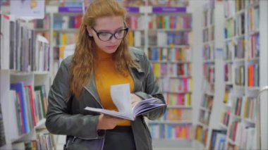 Gözlüklü parlak kızıl saçlı güzel kadın, Kitap Kütüphanesi Üniversitesi 'nde okuyan gözlüklü güzel kız..